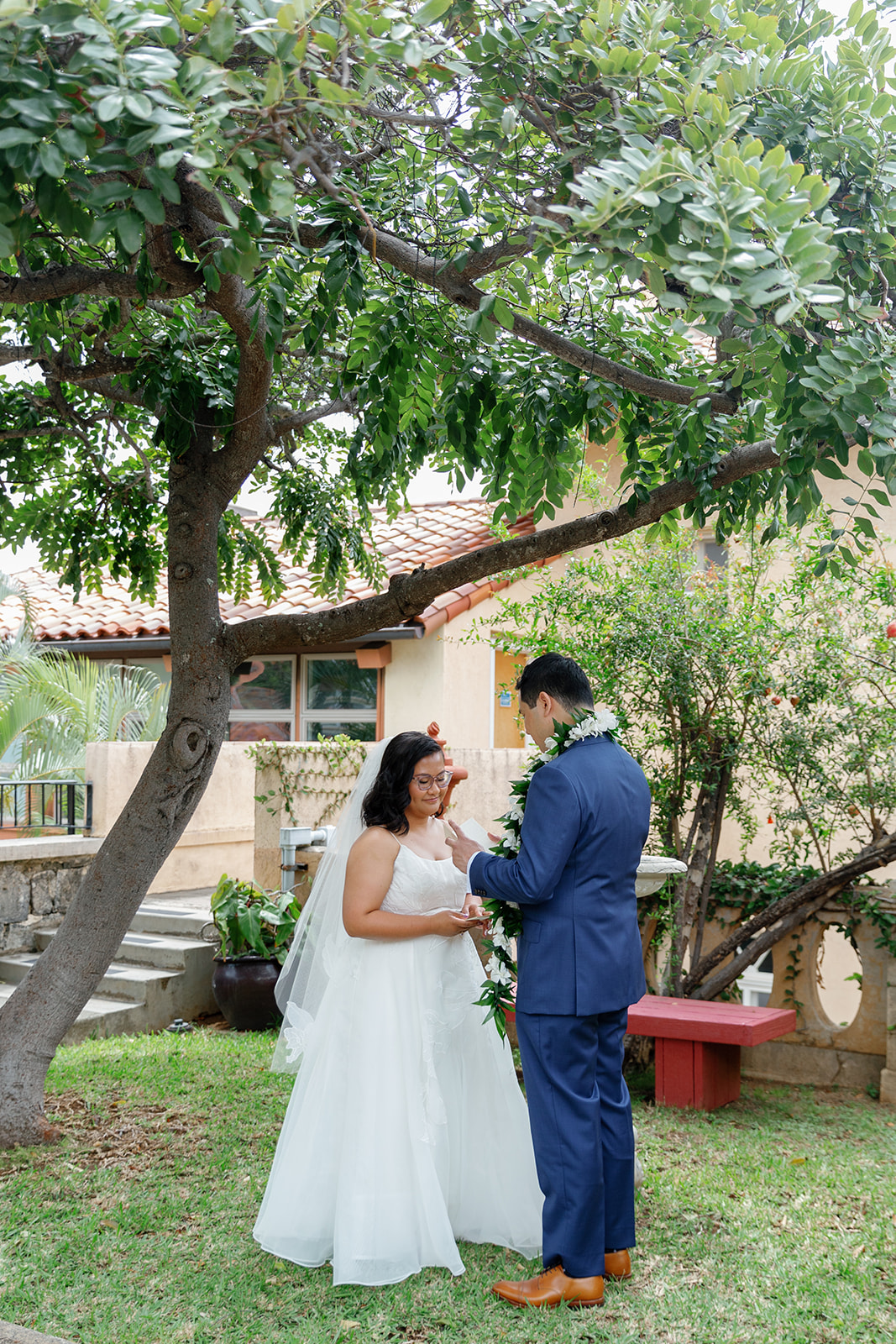 a couple reading private wedding vows to each other underneath a tree at la pietra school 