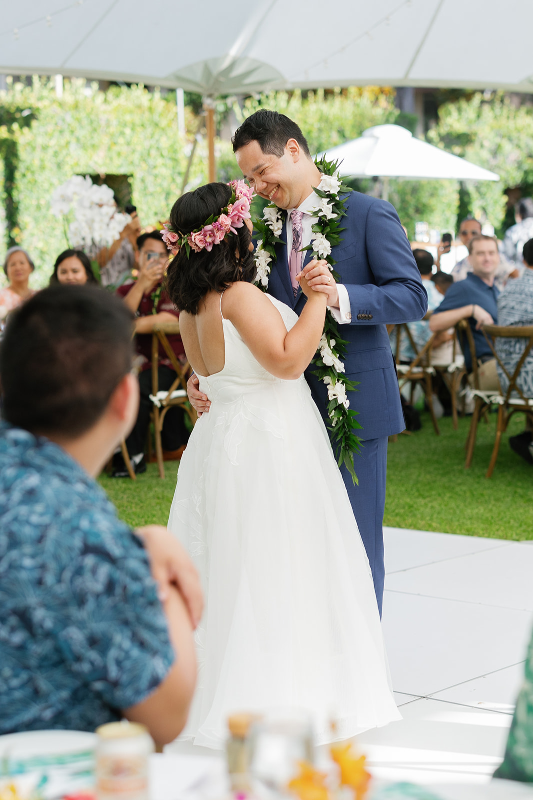 a couple sharing a first dance underneath a white tent at la pietra school