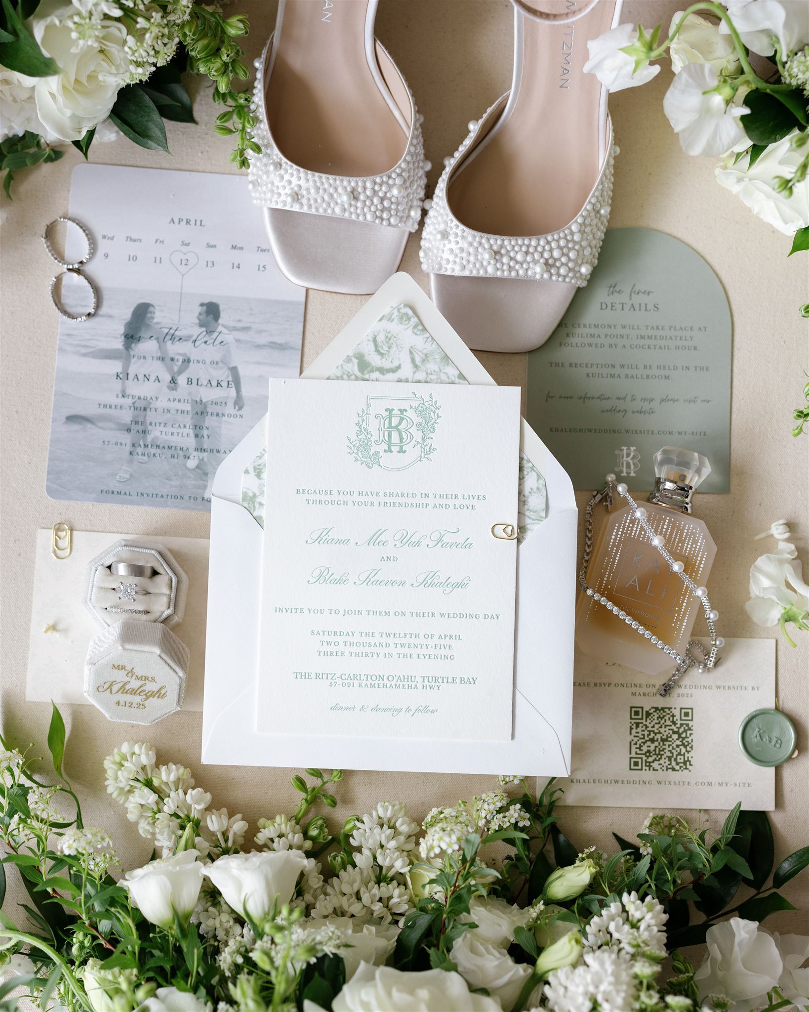a wedding detail flat lay with wedding inviations, heels, perfume, and flowers 