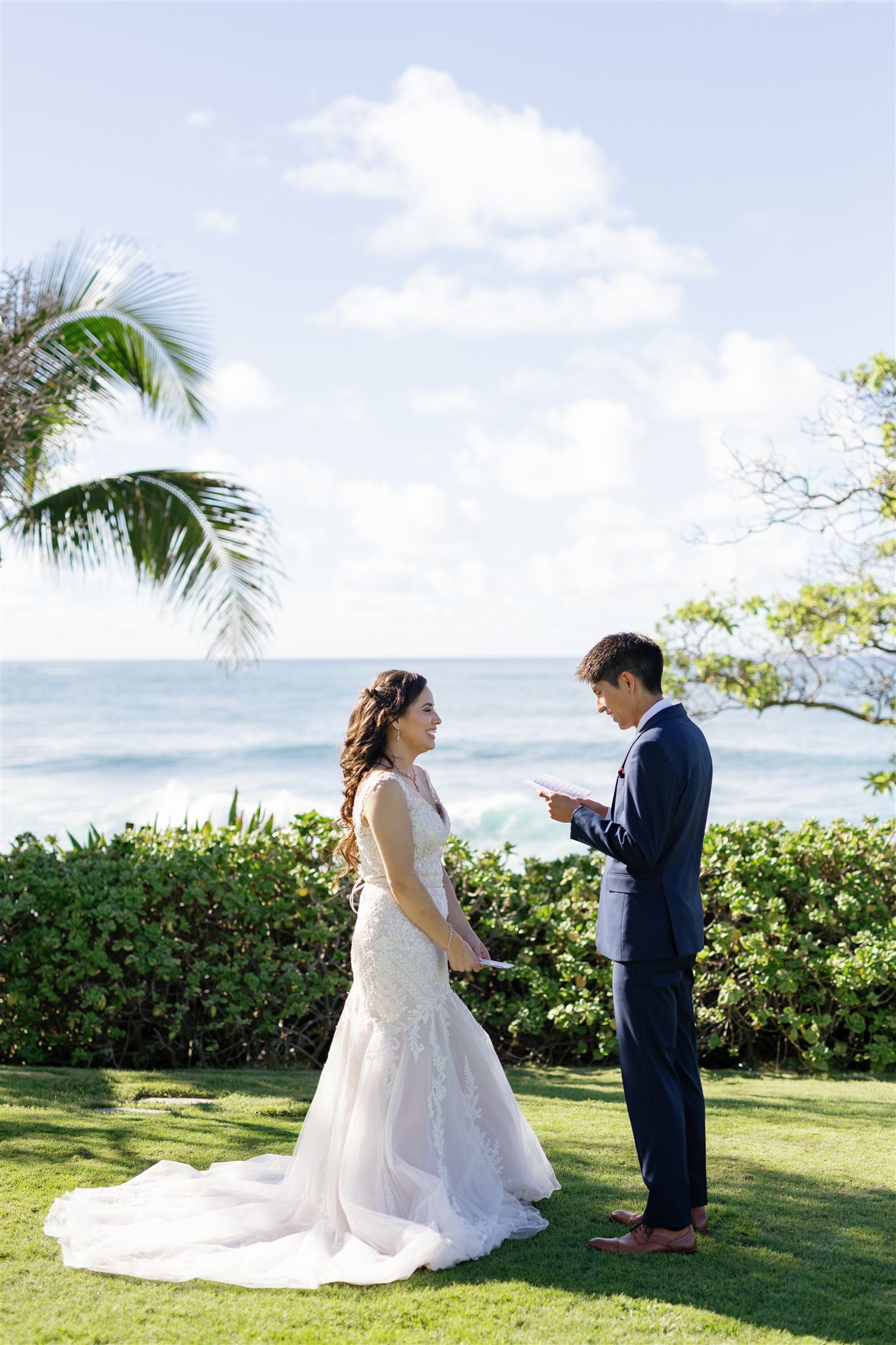 a couple reading private vows to each other next to the ocean at Ritz-Carlton O'ahu, Turtle Bay