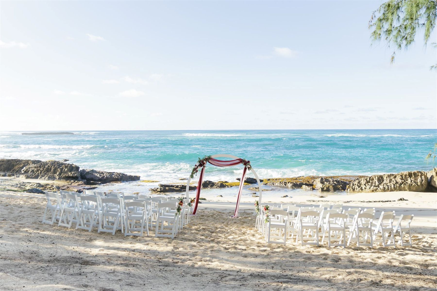 a wedding ceremony set up on the beach in hawaii at Ritz-Carlton O'ahu, Turtle Bay next to the ocean