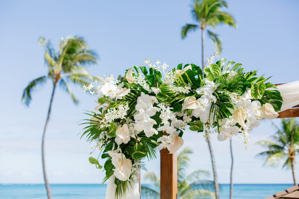 A close up of a floral arch on the corner of a wedding arch 