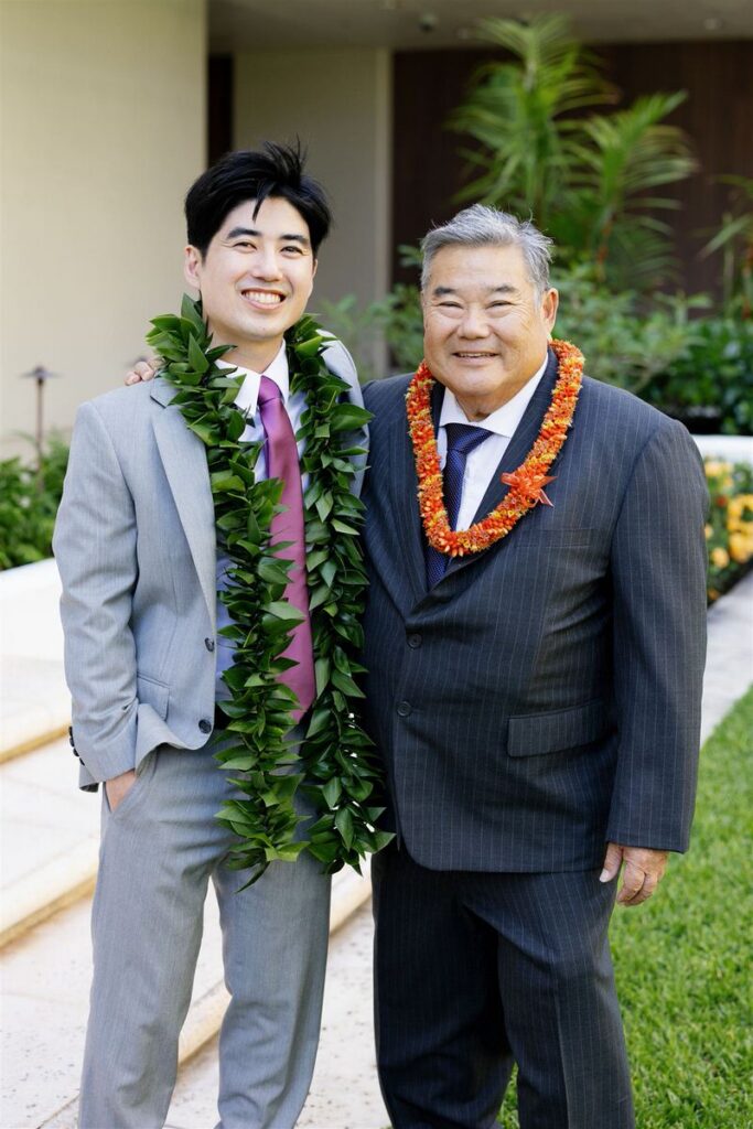 A newlywed smiling with a family member next to them 