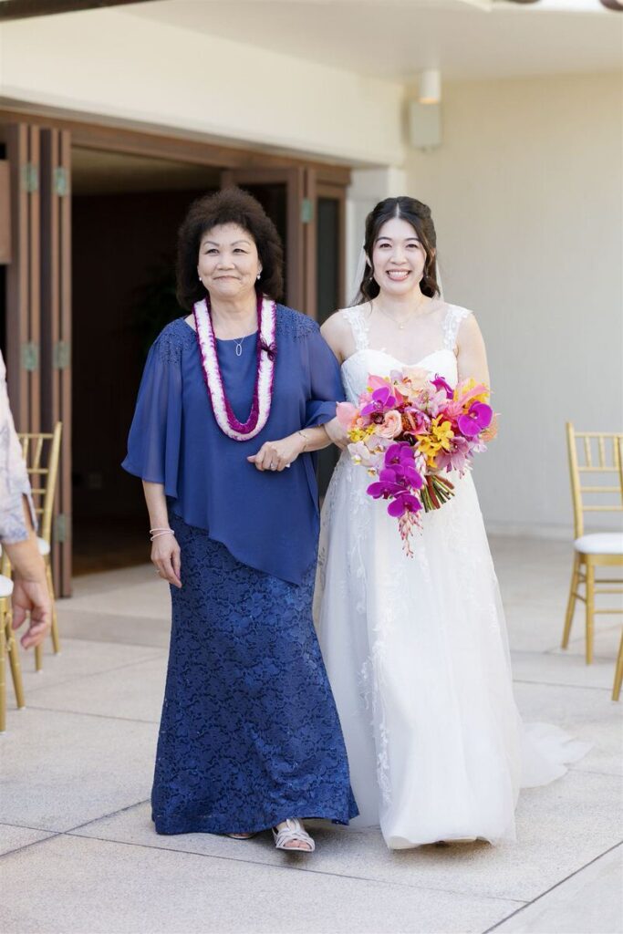 A person in a wedding dress walking down the aisle with a family memeber 