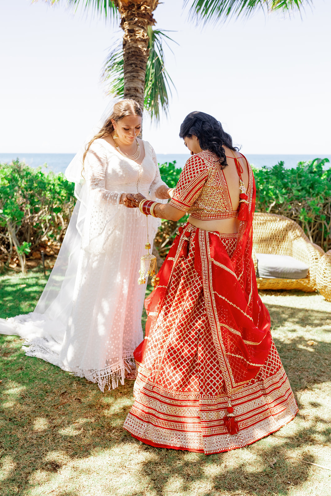 two women sharing a first look next to the ocean at  the Four Seasons Resort on Oahu