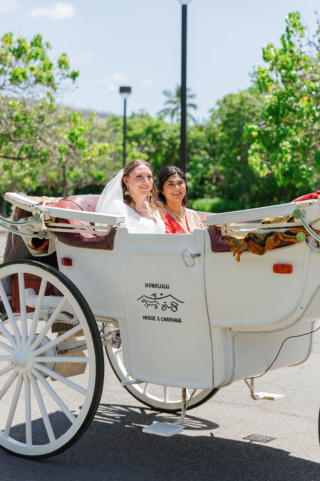 two women arriving to their wedding in a horse drawn carriage 