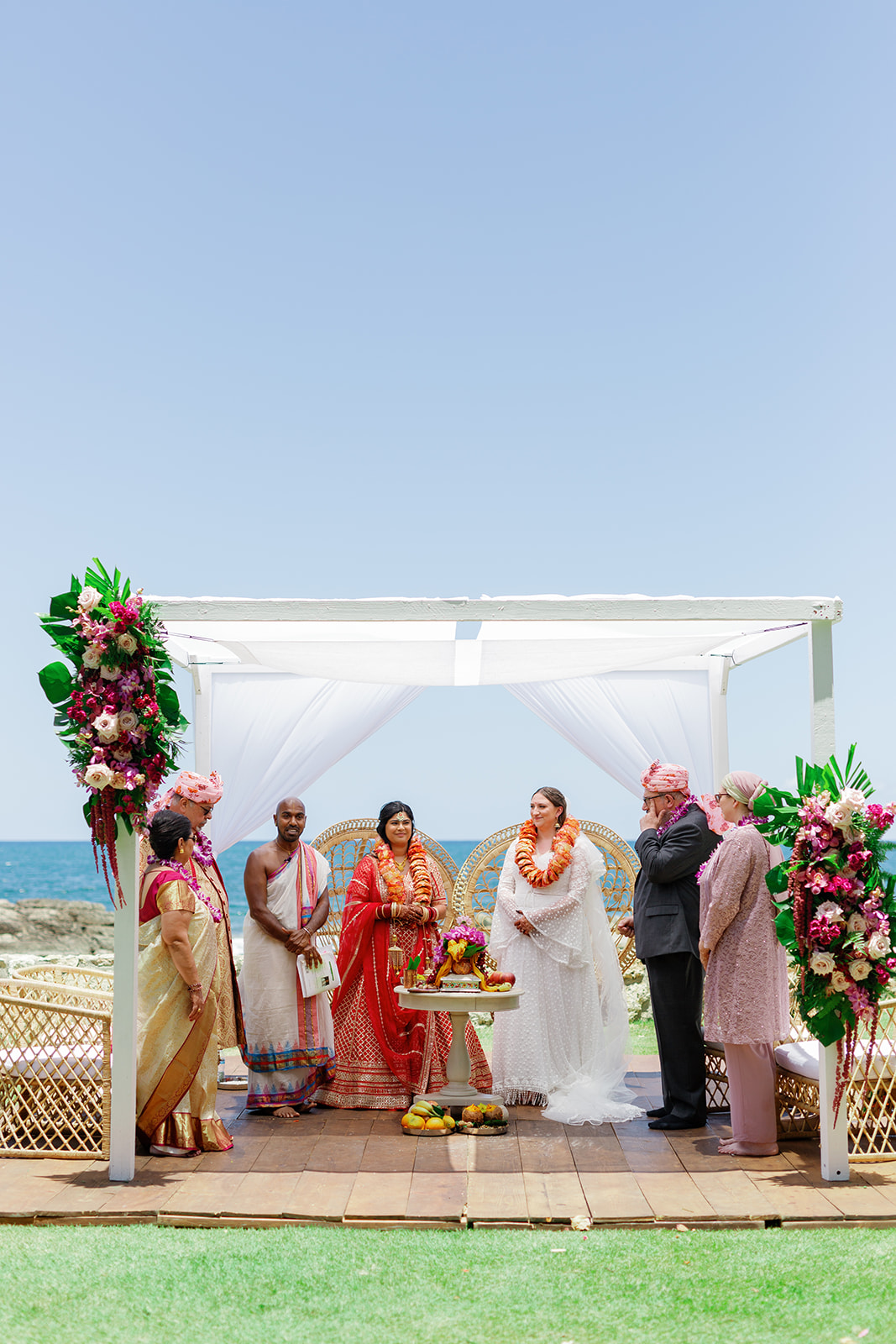 two women having their wedding ceremony next to the ocean at  the Four Seasons Resort on Oahu