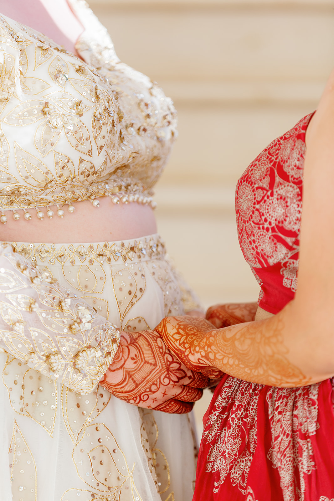 two women both with henna holding hands