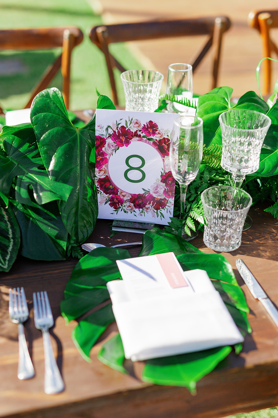 a wooden table elegantly decorated with plants, vases, and cutlery for a wedding reception 