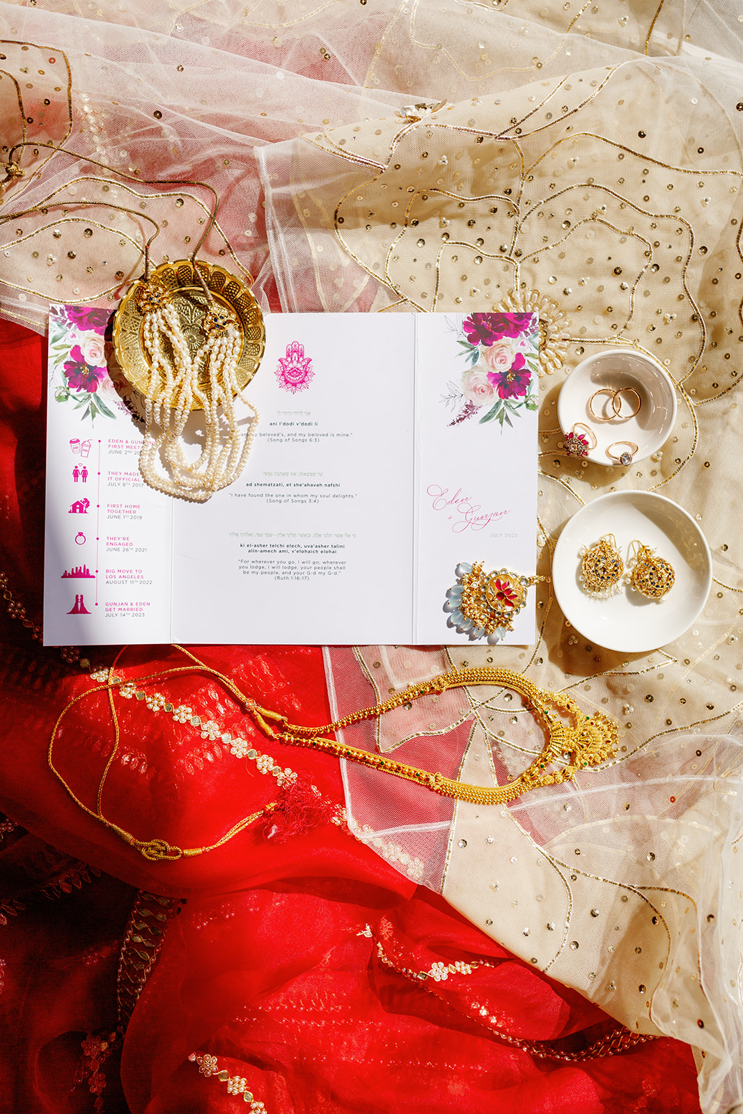 a wedding invitation, jewelry, and two different colored dresses 