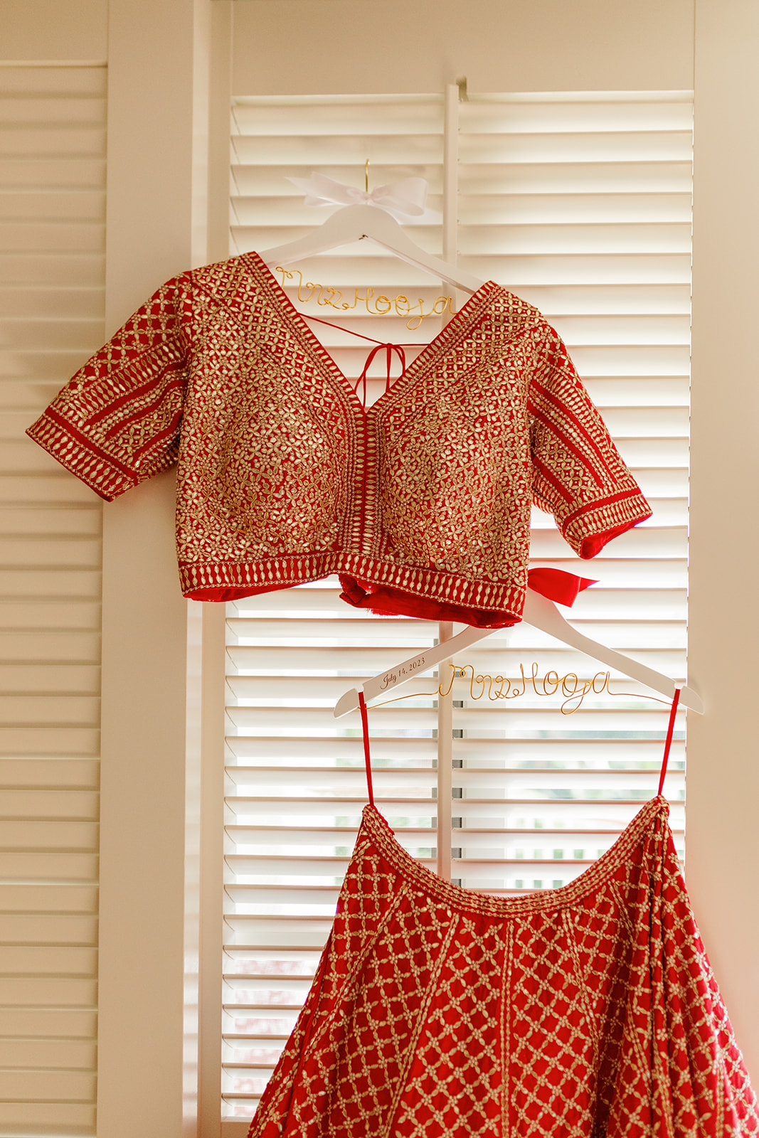 a red top and skirt handing next to a window 