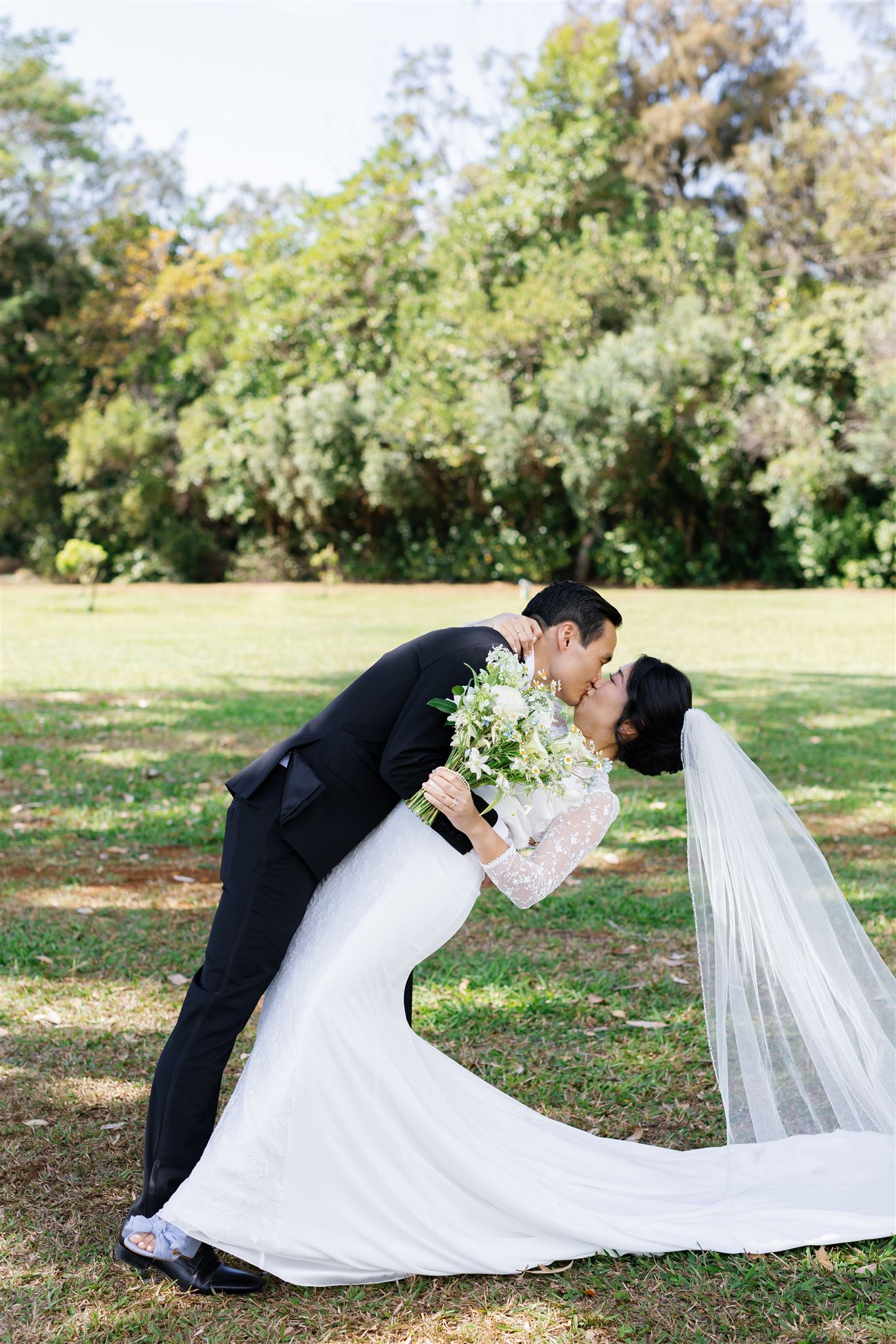a groom dipping his bride backwards and kissing her
