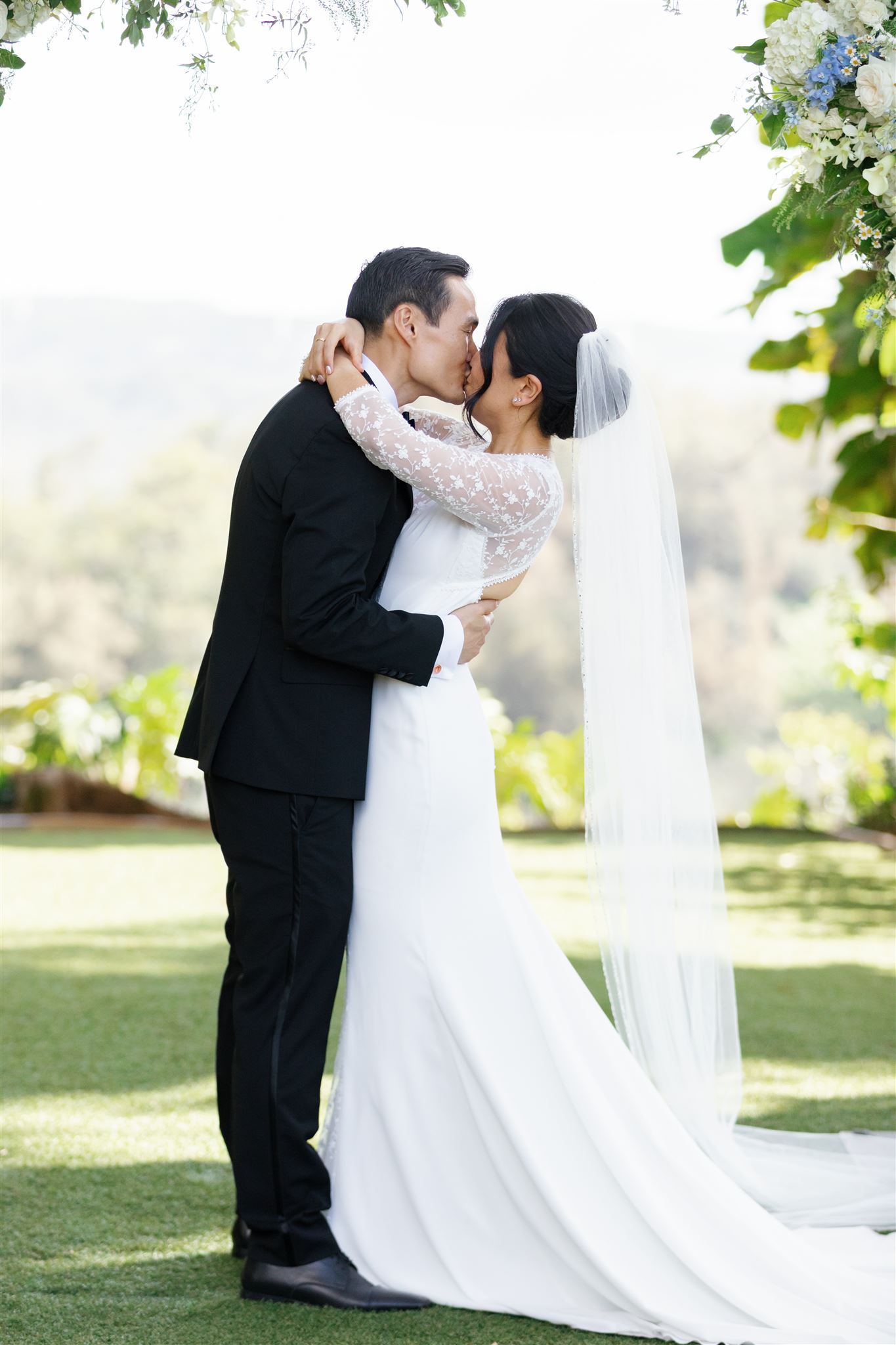 a couple kissing and embracing each other after their wedding ceremony