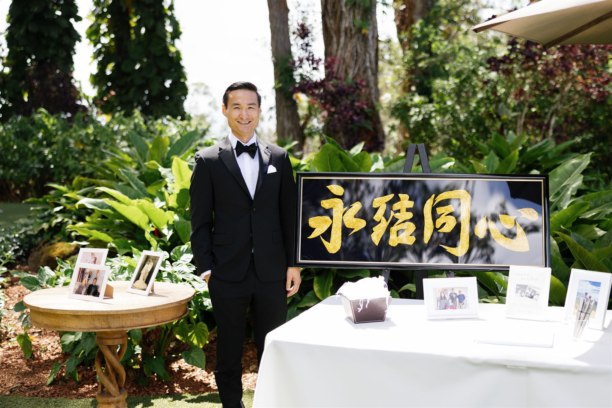 a man dressed up for his wedding standing next to a table 