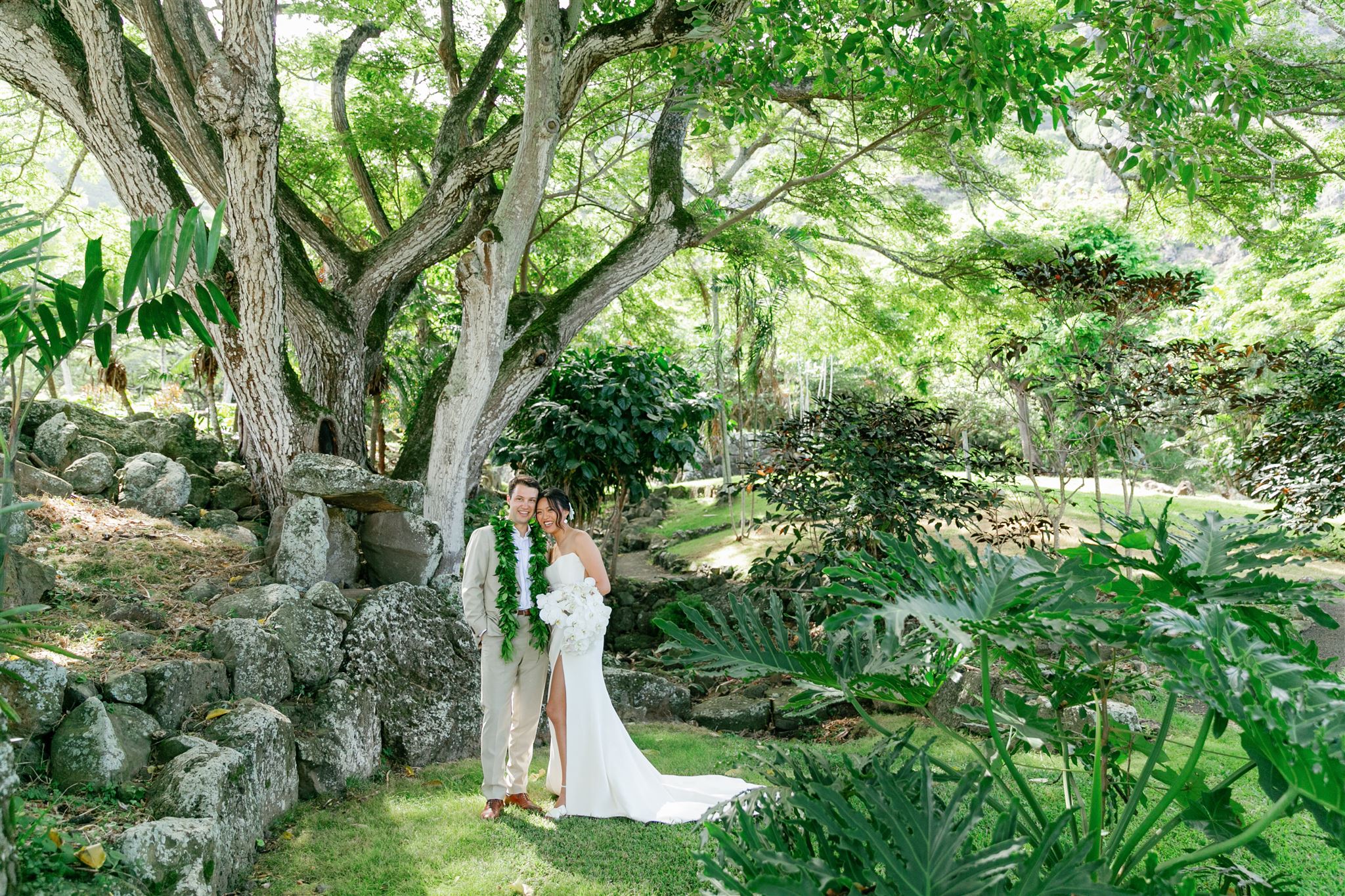 a bride and groom taking wedding portraits at Paliku Gardens at Kualoa Ranch