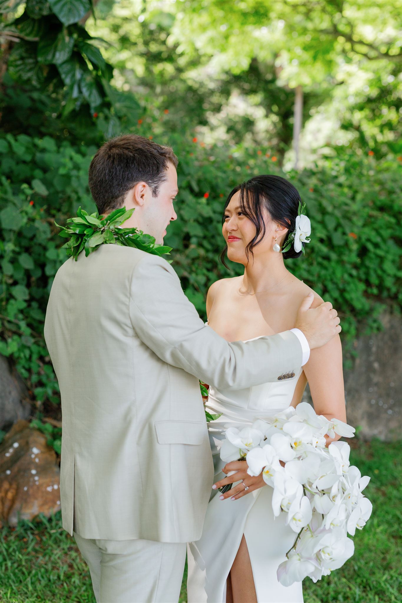 a bride and groom sharing a first look at Paliku Gardens at Kualoa Ranch