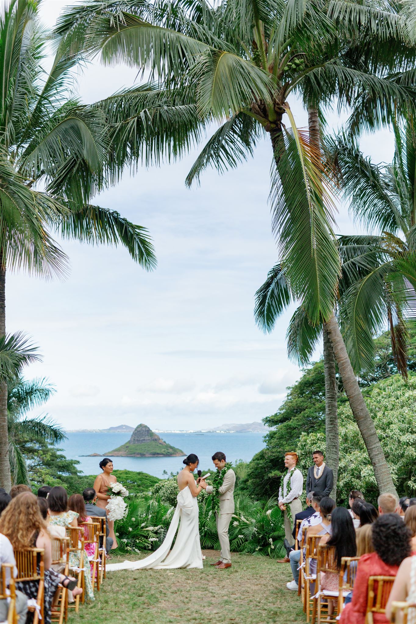 a bride and groom having their wedding ceremony at Paliku Gardens at Kualoa Ranch