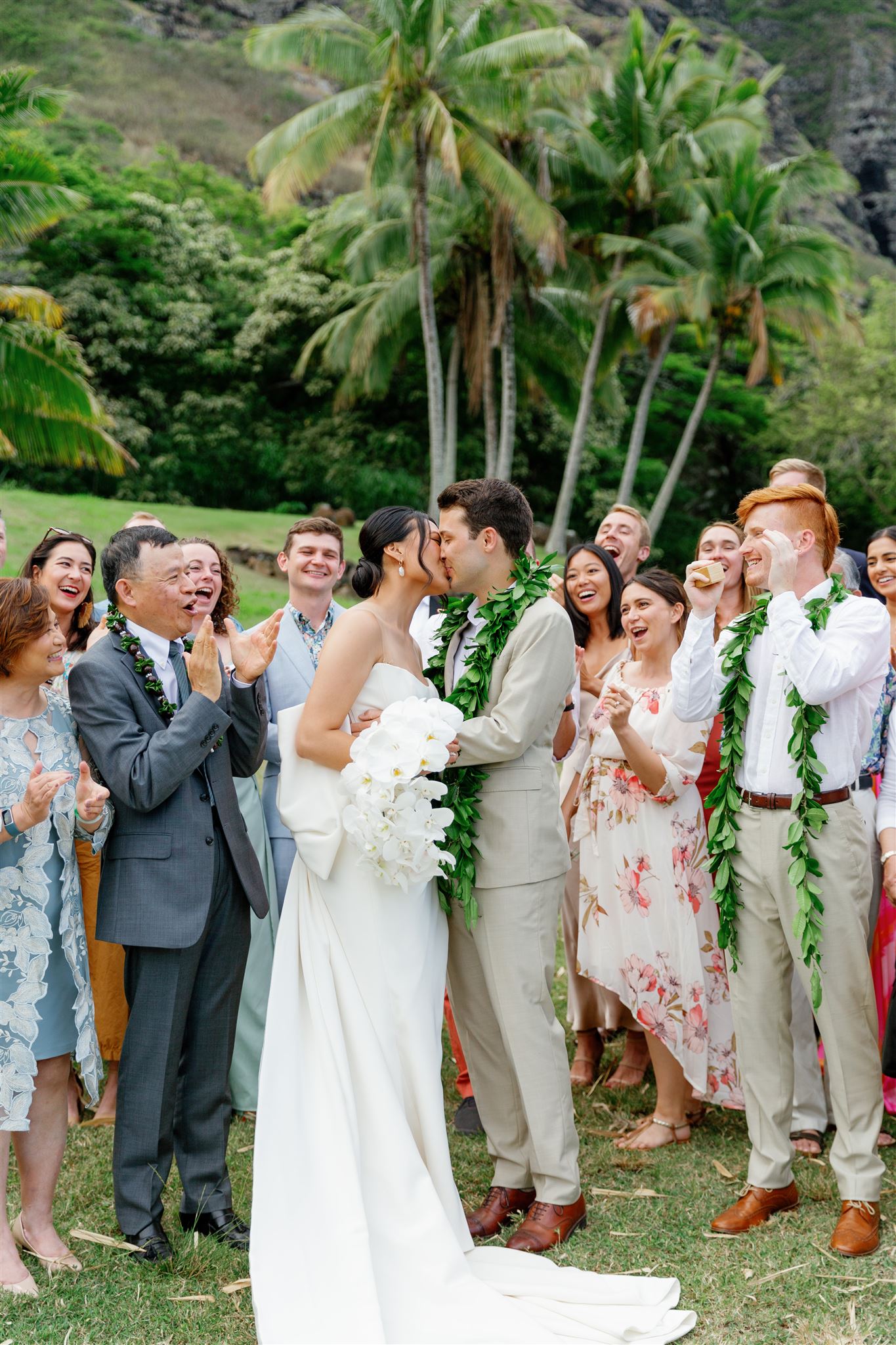a bride and groom kissing in front of their wedding guests 