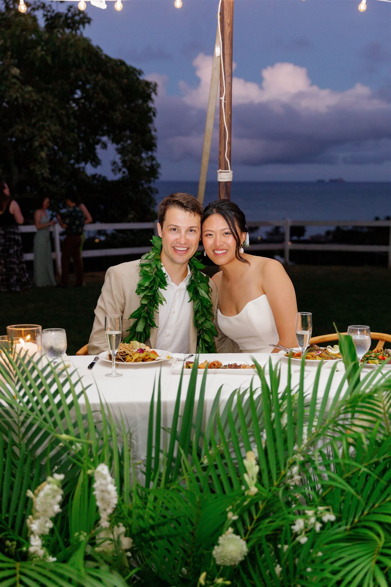 a bride and groom sitting at their table at their wedding reception underneath a white tent 