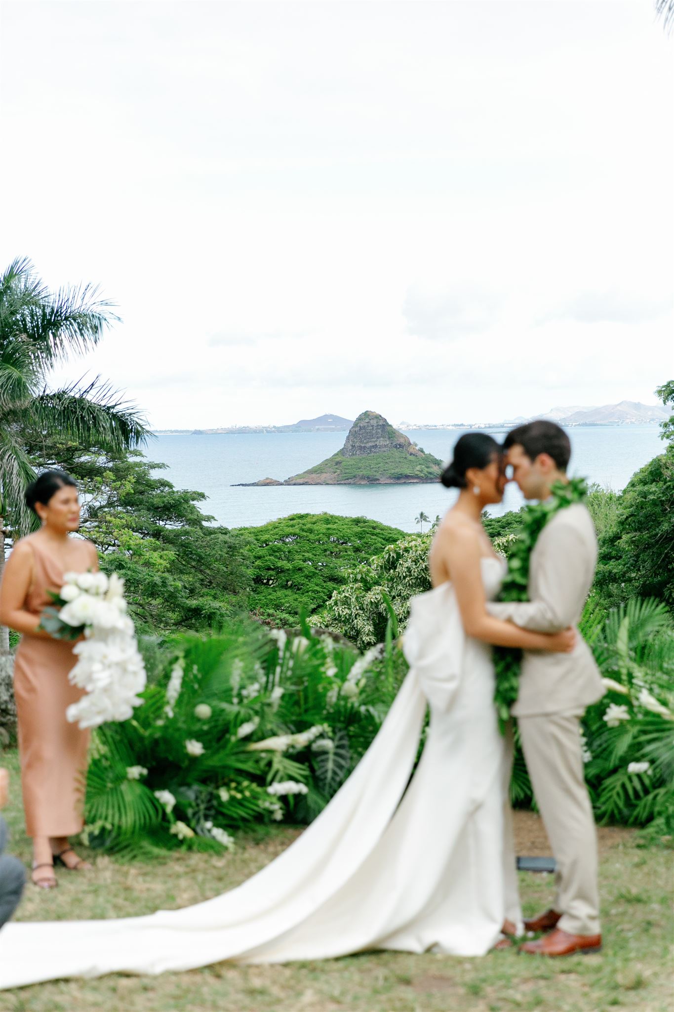 a bride and groom having their wedding ceremony at Paliku Gardens at Kualoa Ranch 