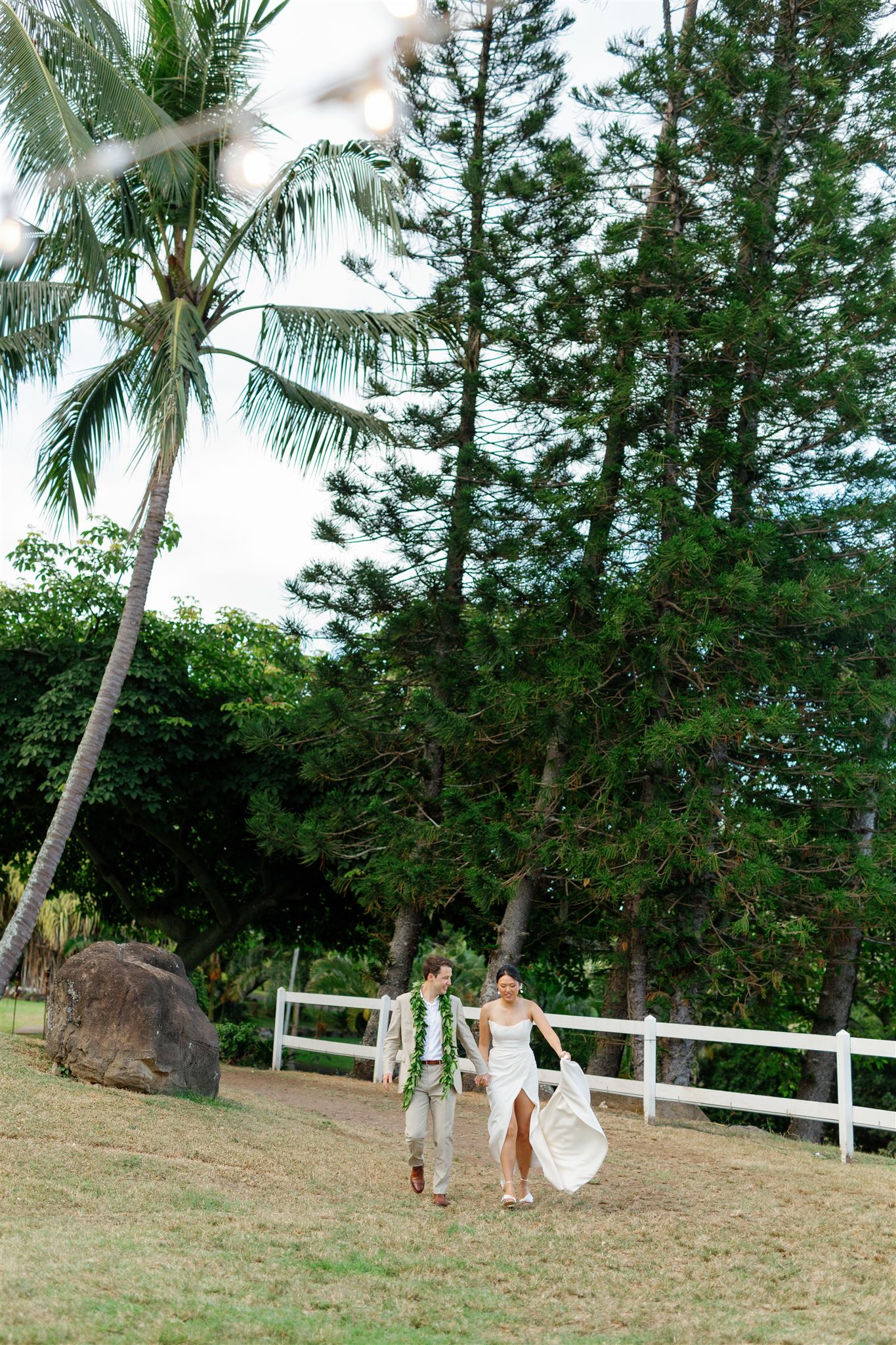 a bride and groom walking across the property at Paliku Gardens at Kualoa Ranch