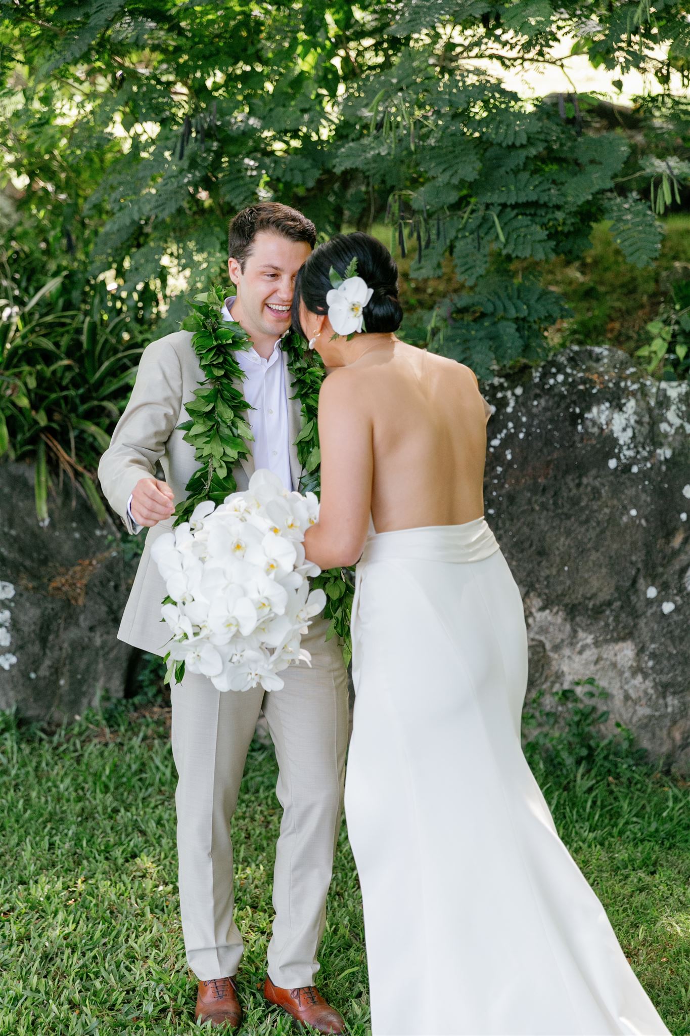 a bride and groom sharing a first look at Paliku Gardens at Kualoa Ranch