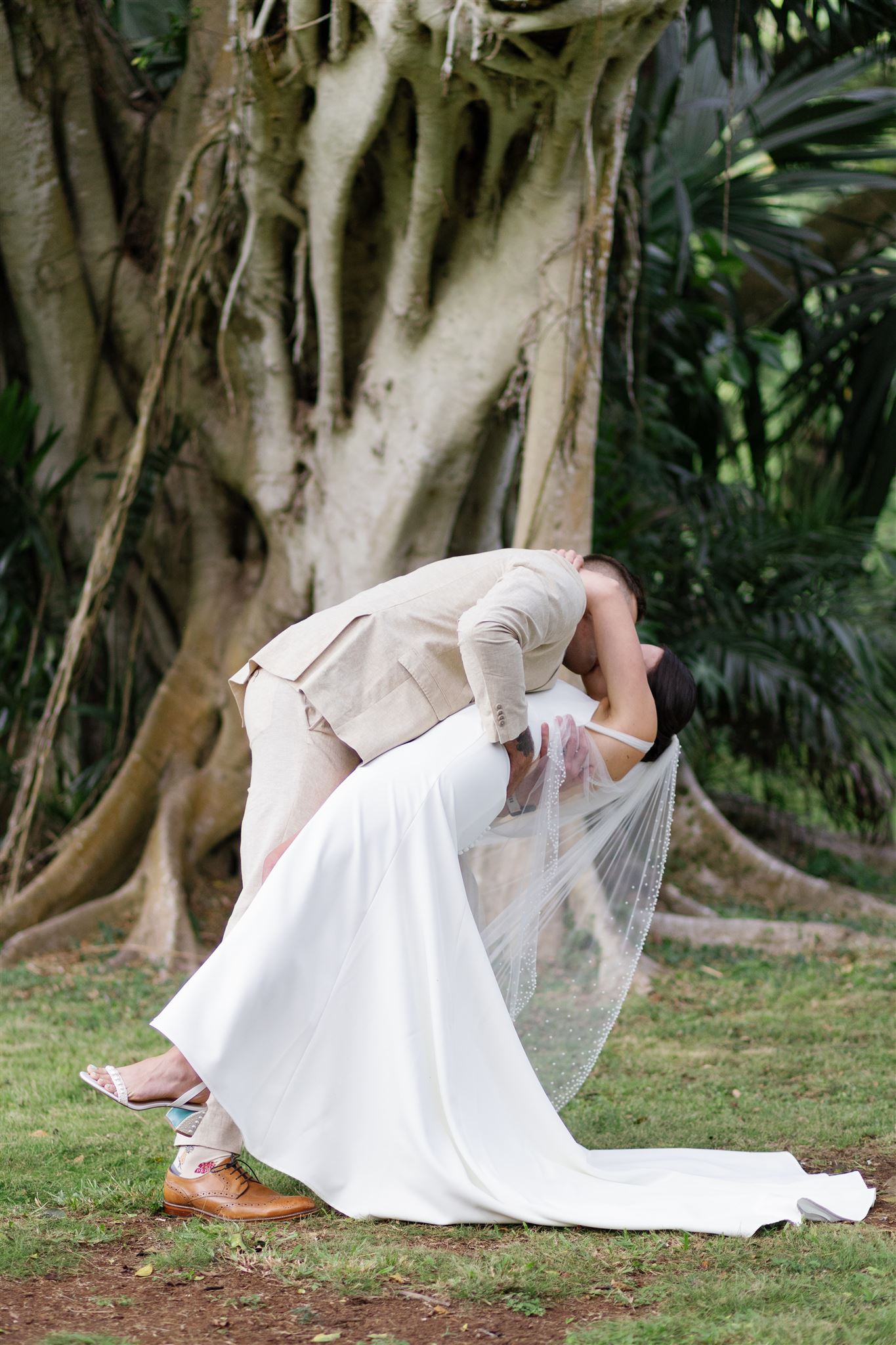 a groom dipping his bride backwards at their wedding ceremony at waimea valley