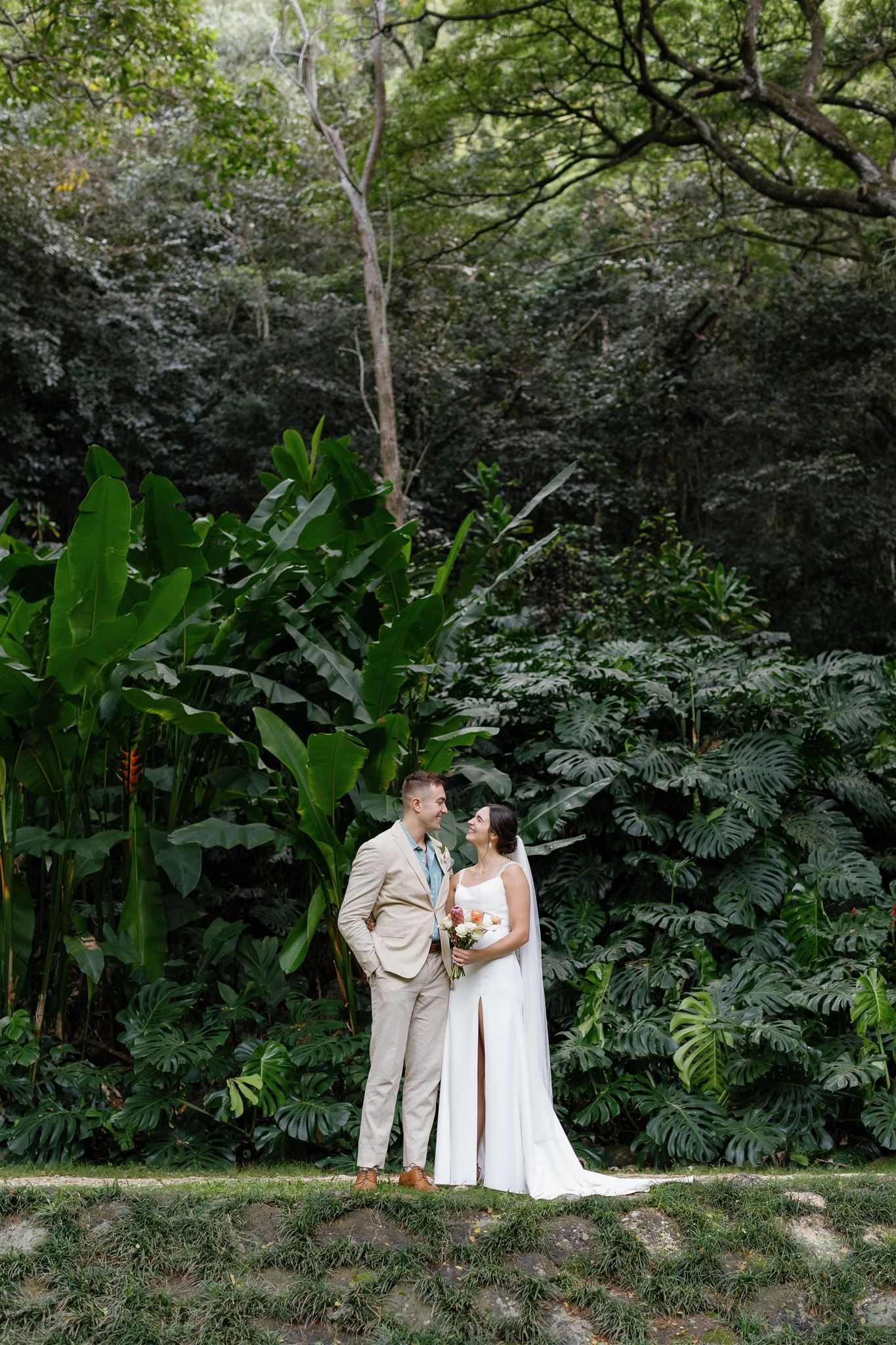 a bride and groom taking wedding portraits in waimea valley