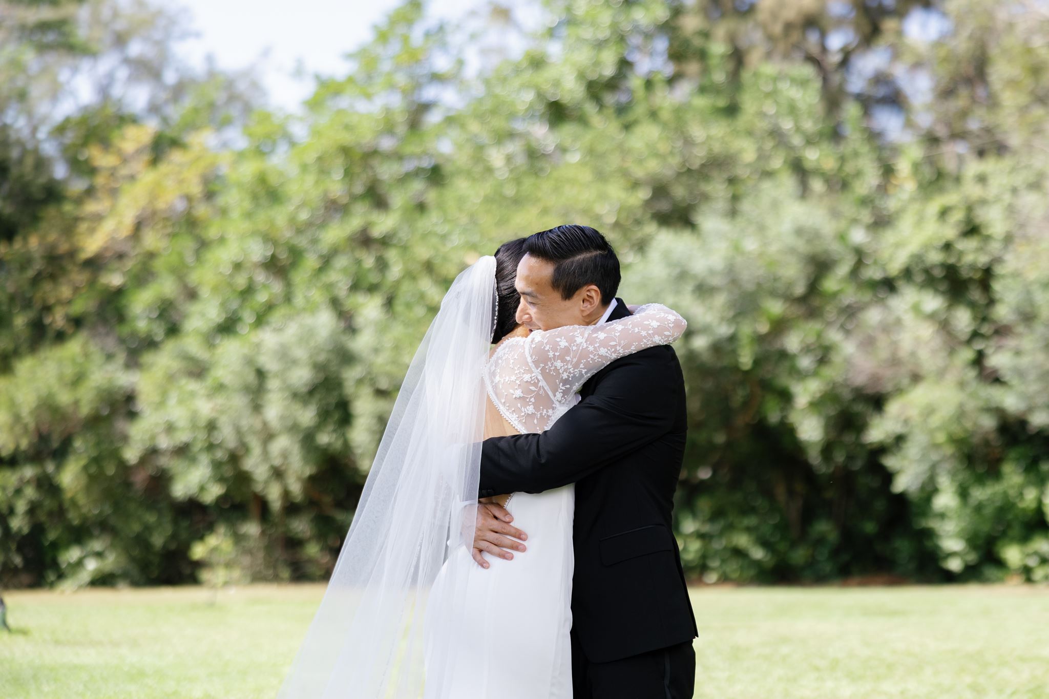 a bride and groom embracing after sharing a first look together