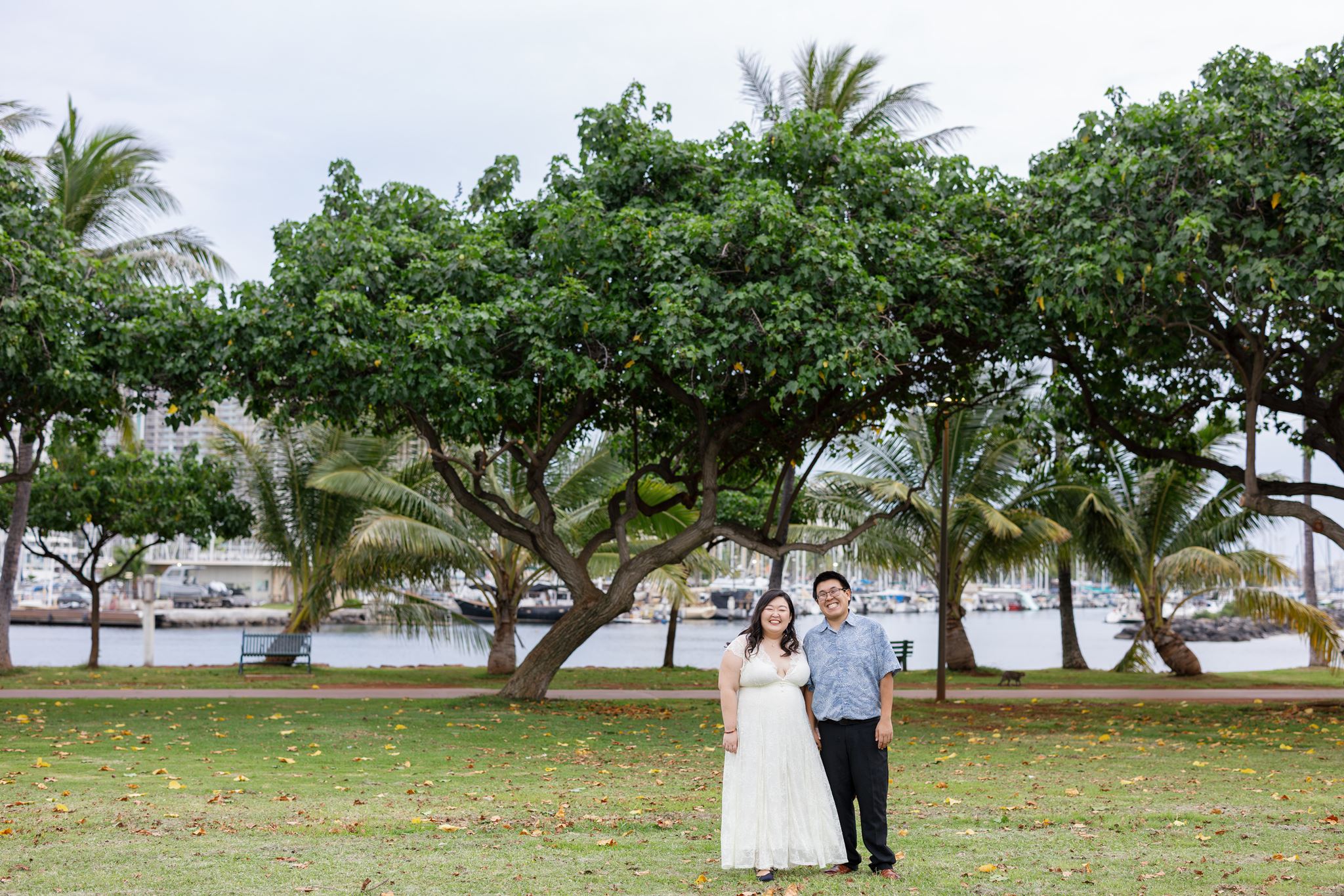 a man and woman standing next to each other with their arms around one another on magic island in hawaii